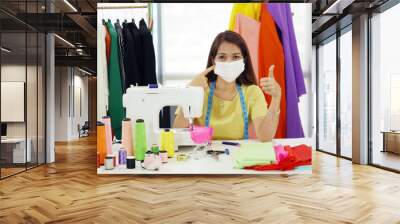 senior woman designer wear mask while she is working in workplace to protect corona virus Wall mural