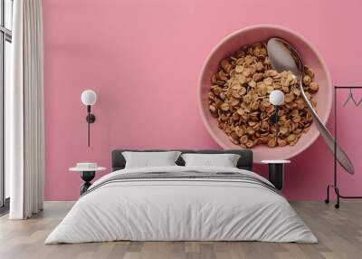 A bowl of cereal with a spoon on a pink surface. Suitable for breakfast concept  Wall mural