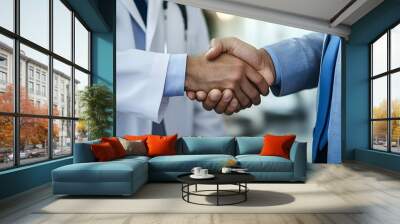 A close-up of two hands shaking, one in business attire and the other with a medical coat, symbolizing trust between a businessman and doctor during an important meeting Wall mural