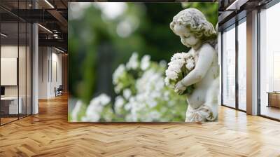 Angel statue at the cemetery, with white flowers on blurry green background, copy space for text, funeral concept Wall mural