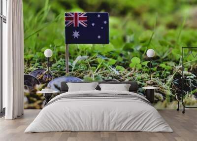 Australian flag and dollar coins amid moss and plant environment Wall mural