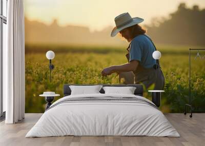 farmer working in lush green field during sunrise, wearing hat and overalls, surrounded by nature beauty. scene evokes sense of tranquility and hard work Wall mural