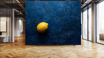 Yellow lemon on dark blue background. Wall mural