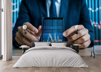 Businessman analyzing stock market data on smartphone screen, showing financial trends and investment insights. Wall mural