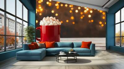 Cozy red mug filled with whipped cream, perfect for a warm drink on a festive evening with sparkling lights in the background. Wall mural