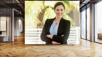 Successful business woman looking confident and smiling, outside Wall mural