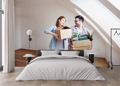 Couple with carton boxes on hands in empty room in new house Wall mural