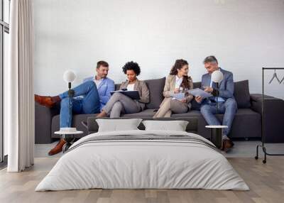 Group of four business people sitting on sofa Wall mural