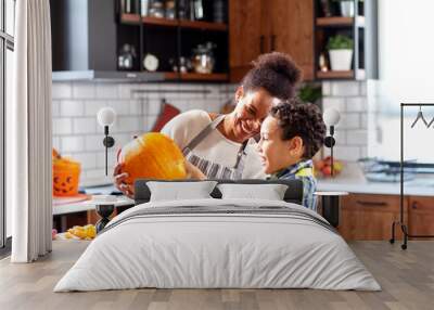 Mother with his son prepare pumpkin for halloween in the kitchen Wall mural