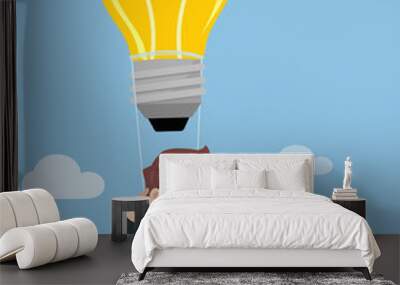 Businessman flying in air balloon with lightbulb.-vector illustr Wall mural