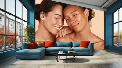 Beauty. Smiling women with perfect face skin and natural makeup portrait. Beautiful happy asian and african girl models with different types of skin on beige background. Spa skin care concept Wall mural