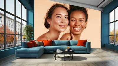 Beauty. Smiling women with perfect face skin and natural makeup portrait. Beautiful happy asian and african girl models with different types of skin on beige background. Spa skin care concept Wall mural