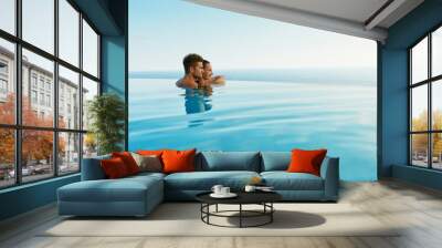 Couple In Love At Luxury Resort On Romantic Summer Vacation. People Relaxing Together In Edge Swimming Pool Water, Enjoying Beautiful Sea View. Happy Lovers On Honeymoon Travel. Relationship, Romance Wall mural