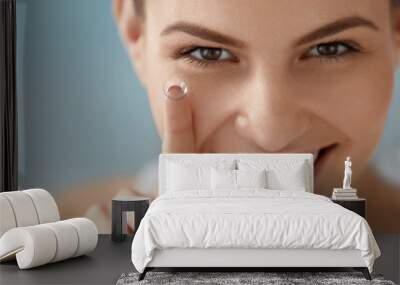 Eye care. Smiling woman with contact eye lens on finger closeup Wall mural