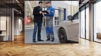 mechanic and customer discussing problem with car. Wall mural