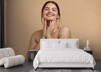 Smiling Woman Touching Face. Waist up Portrait of Attractive Woman Touching her Skin and Smiling While Applying Moisturiser. Woman Appearance and Skin Care Concept  Wall mural