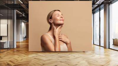 Smiling Woman Touching Neck. Waist up Portrait of Attractive Woman Touching her Skin and Smiling with Closed Eyes. Woman Appearance and skin Care Concept  Wall mural