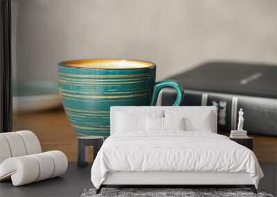 A cup of coffee and a Bible on a wooden table, close-up. Wall mural