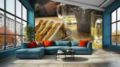 A piece of cake on a plate and a cup close-up on a table in a cafe. Wall mural