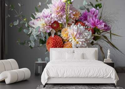 A woman is holding a festive bouquet with chrysathemum flowers in her hands. Wall mural