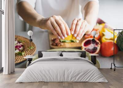 A woman makes a fresh vegetable salad, close-up. Wall mural