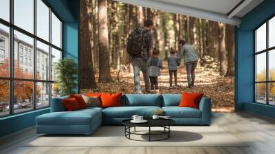 A young family walks in the autumn forest with children. Wall mural