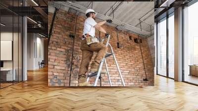 Electrician with tools, working on a construction site. Repair and handyman concept. Wall mural