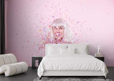 Funny Girl with silver hair gives a smile and emotion on pink background. Young woman or teen girl with confetti Wall mural