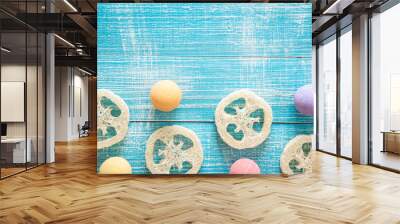 Multicolored bath bombs and loofahs on a blue wooden background. Wall mural