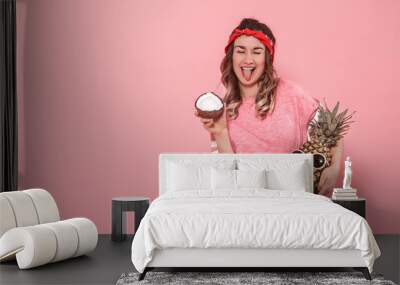 Portrait of a girl with fruit on a pink background Wall mural