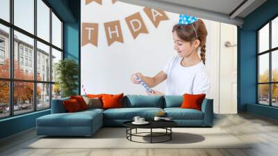 The girl decorates the festive table for her birthday. Birthday concept. Wall mural