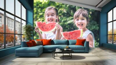 two little cute girls eating watermelon outdoors Wall mural