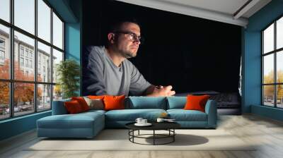 Young man works at the computer at night. Wall mural