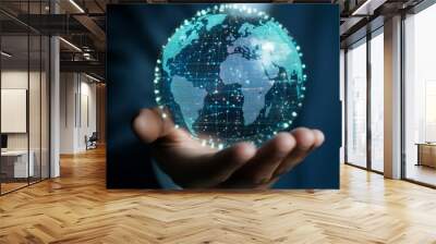 A businessman holds a glowing, digital globe in his hand, representing global connection and technology. Wall mural