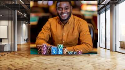 A smiling man in a casino sitting at a table with chips in front of him. Wall mural