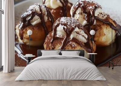 Four profiteroles with whipped cream and chocolate sauce on a white plate. Wall mural