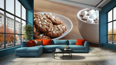 A cozy arrangement of cookies and hot chocolate topped with marshmallows on a wooden table. Wall mural