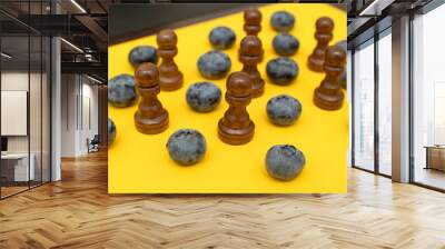 Black wooden chess pawns and blueberry Wall mural