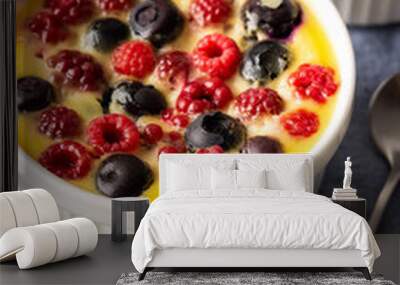 Delicious clafoutis made from white yogurt and berries, raspberries and blueberries, clafoutis in portioned bowls on the table Wall mural