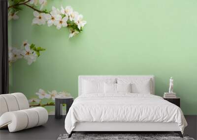 Festive banner with spring flowers, flowering cherry branches on a light green pastel background Wall mural