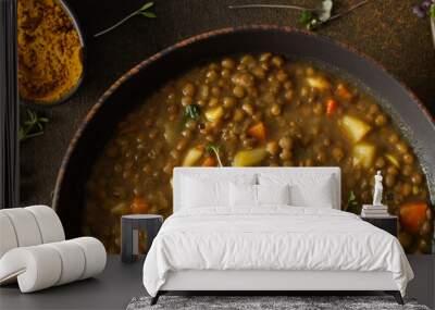 Healthy vegetarian lunches banner, brown lentil soup with tomatoes and carrots, potatoes and curry spices, toasted croutons, bowl with soup on cutting board on brown background Wall mural