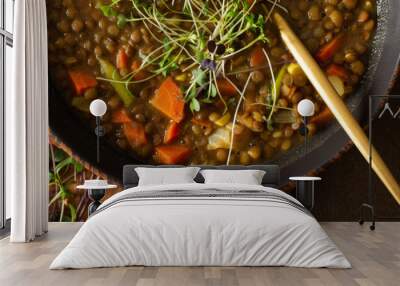 Healthy vegetarian lunches banner, brown lentil soup with tomatoes and carrots, potatoes and curry spices, toasted croutons, bowl with soup on cutting board on brown background Wall mural