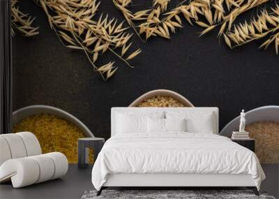 Various grain cereals in bowls banner, top view on a brown background with bowls of cereals and ears of oats Wall mural