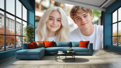 A beautiful young woman with long blonde hair and blue eyes, wearing a white t-shirt, poses next to her boyfriend who has short brown hair in the city in illustrator style  Wall mural