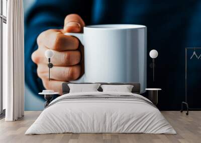 Close-up of a hand holding a plain white mug, background blurred, concept of morning coffee. Wall mural