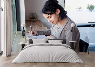 black woman studies her bible while drinking coffee and making notes Wall mural