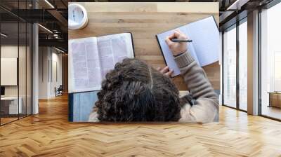 top view of woman journaling as she reads and works on a bible study Wall mural