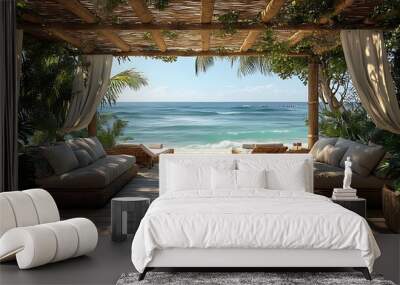 A wooden pergola with white curtains overlooks a tropical beach with white sand and blue ocean. Wall mural