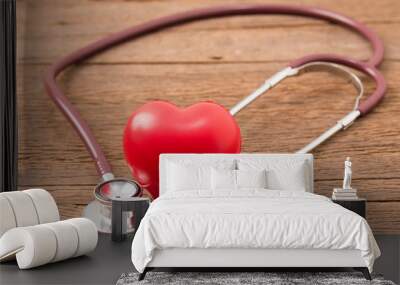 Heart beat diagnose concept. Stethoscope and red heart on wooden background. Wall mural