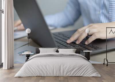 Businesswoman's hand presses on a laptop keyboard, World of technology and internet communication, Using computers to conduct financial transactions because the convenience and speed. Wall mural